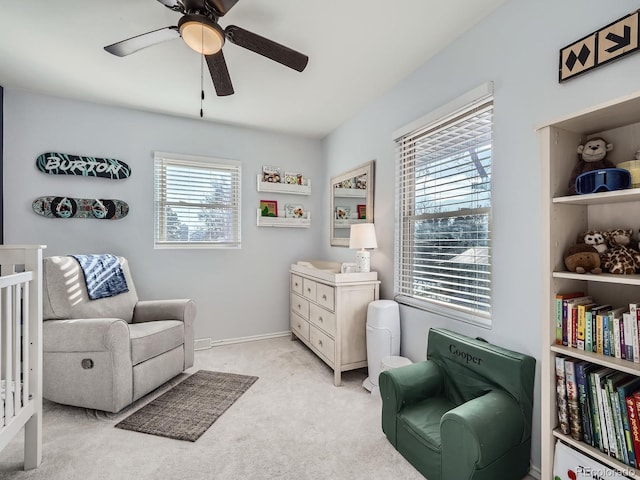 sitting room with ceiling fan and light colored carpet