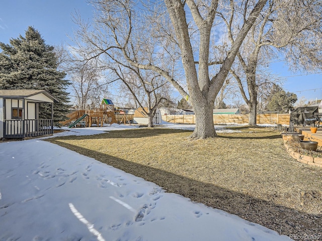 snowy yard with an outbuilding and a playground