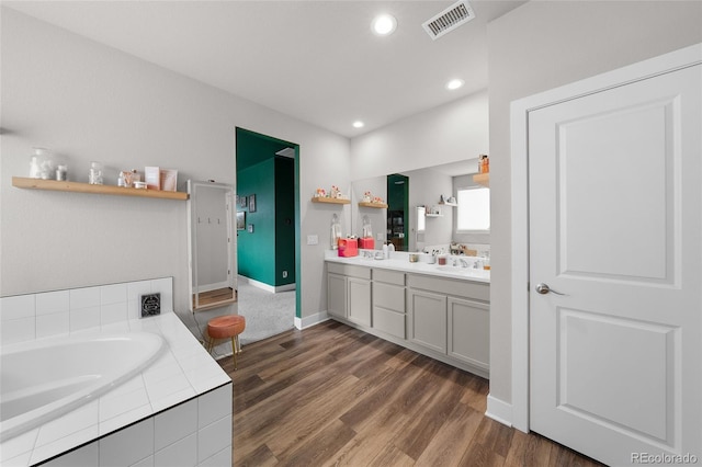 199 Simmental Loop, Castle Rock, CO 80104 - full bathroom with double vanity, a bath, wood finished floors, baseboards, and recessed lighting