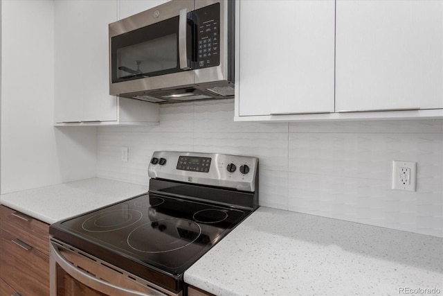 334 Old Stage Rd Unit B, Salida, CO 81201 - kitchen with stainless steel appliances, tasteful backsplash, white cabinetry, and light stone countertops