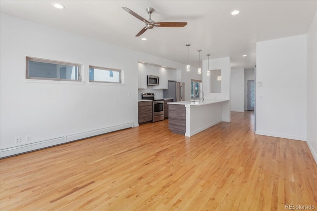 334 Old Stage Rd Unit B, Salida, CO 81201 - kitchen with stainless steel appliances, light countertops, a kitchen bar, light wood-type flooring, and recessed lighting