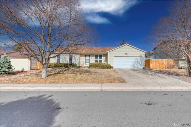 ranch-style home with concrete driveway, an attached garage, and fence