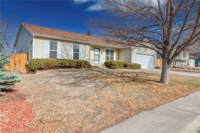 ranch-style home with a garage, concrete driveway, and fence