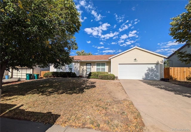 single story home featuring concrete driveway, an attached garage, and fence