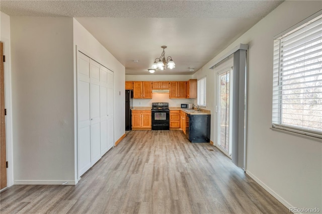 kitchen with light wood-style flooring, black appliances, and light countertops