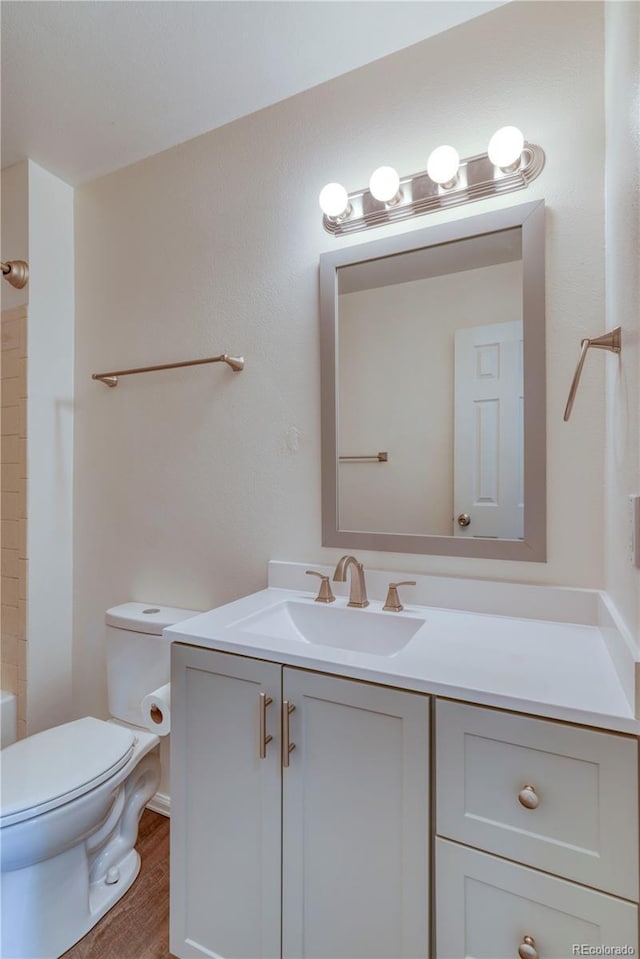 full bath featuring toilet, vanity, and wood finished floors