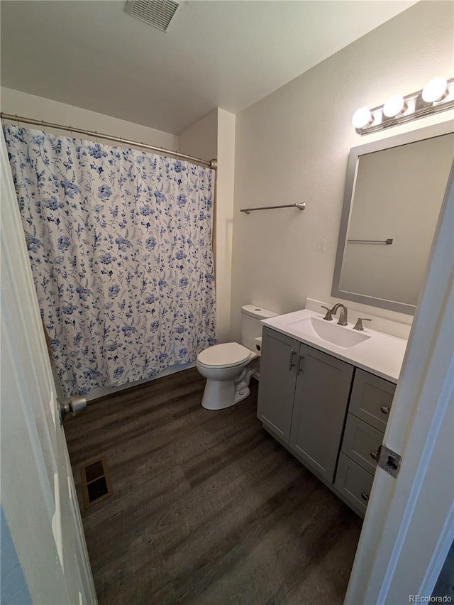 full bathroom featuring visible vents, vanity, and wood finished floors