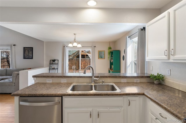 kitchen with a sink, a wealth of natural light, stainless steel dishwasher, and open floor plan