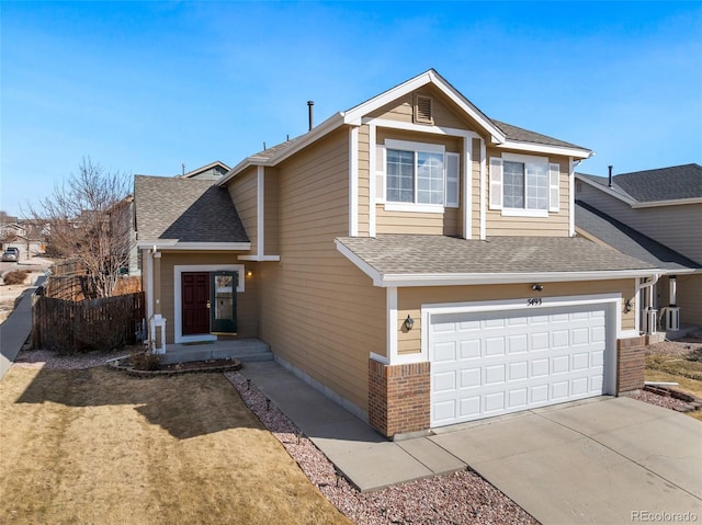 traditional-style home featuring a garage, fence, driveway, and roof with shingles