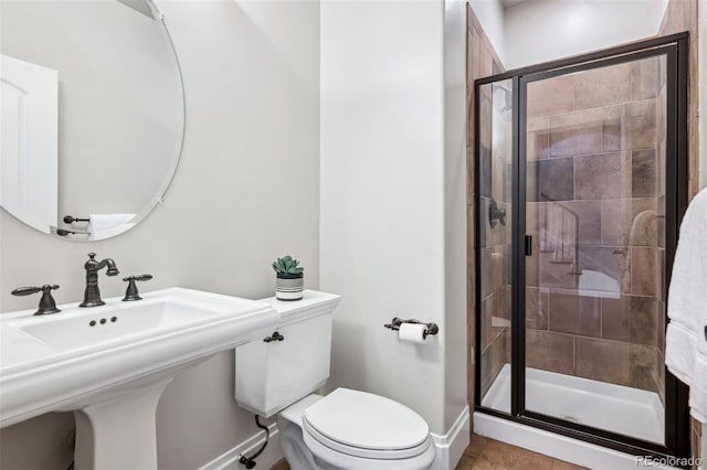 bathroom featuring an enclosed shower, sink, and toilet