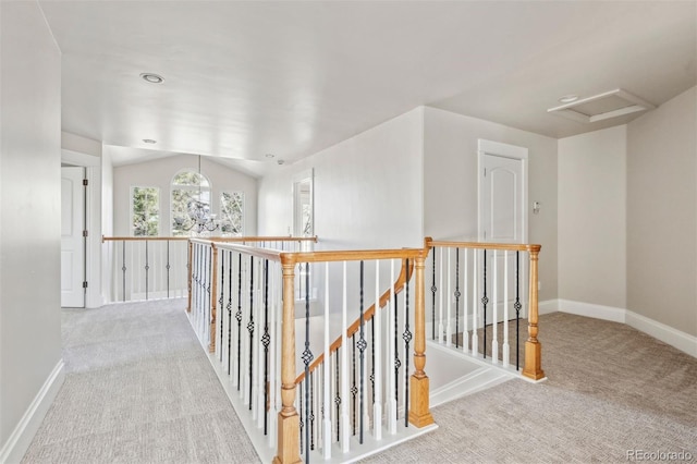 hallway with lofted ceiling, light carpet, and a notable chandelier