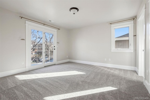 carpeted empty room featuring baseboards