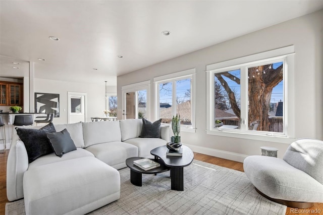 living room featuring light wood finished floors, baseboards, and recessed lighting