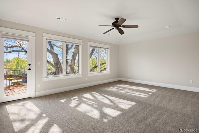 carpeted spare room with plenty of natural light, baseboards, and a ceiling fan