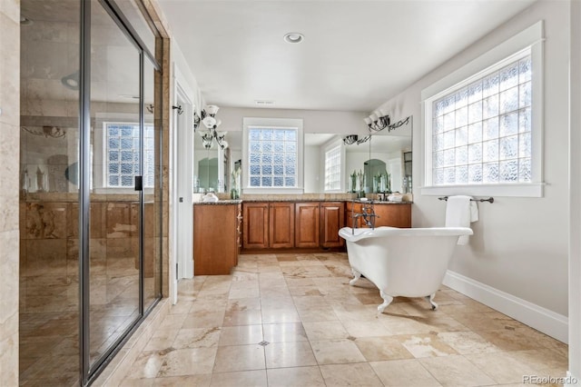full bath featuring a shower stall, baseboards, vanity, and a soaking tub