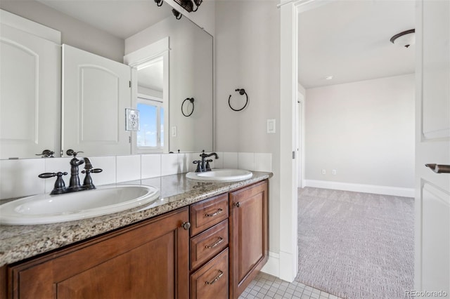 full bath featuring double vanity, baseboards, and tile patterned floors
