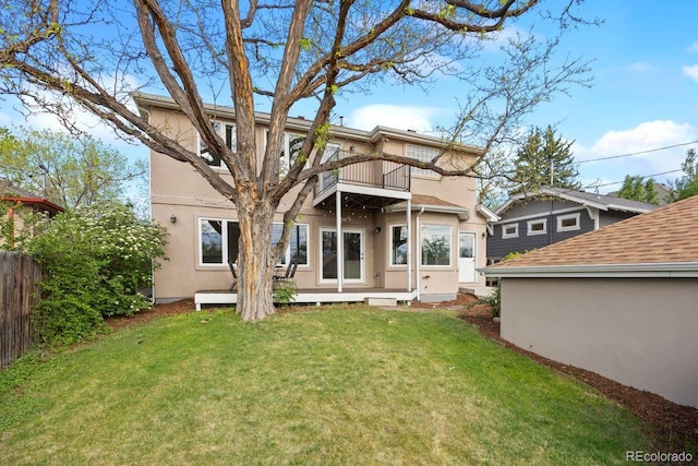 back of property featuring a balcony and stucco siding