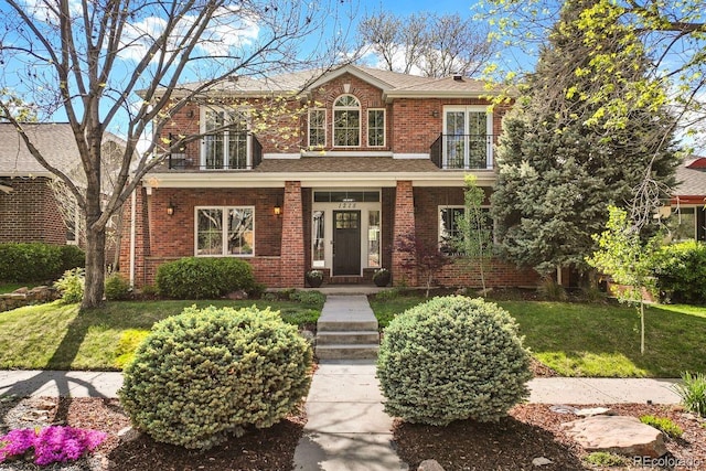 1215 S Ogden St, Denver, CO 80210 - view of front facade with brick siding, a front lawn, covered porch, a shingled roof, and a balcony