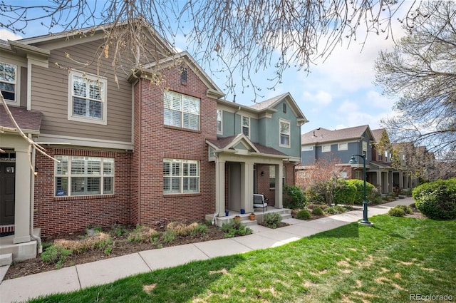 767 Roslyn St Unit 20, Denver, CO 80230 - view of front facade featuring a residential view, a front lawn, and brick siding