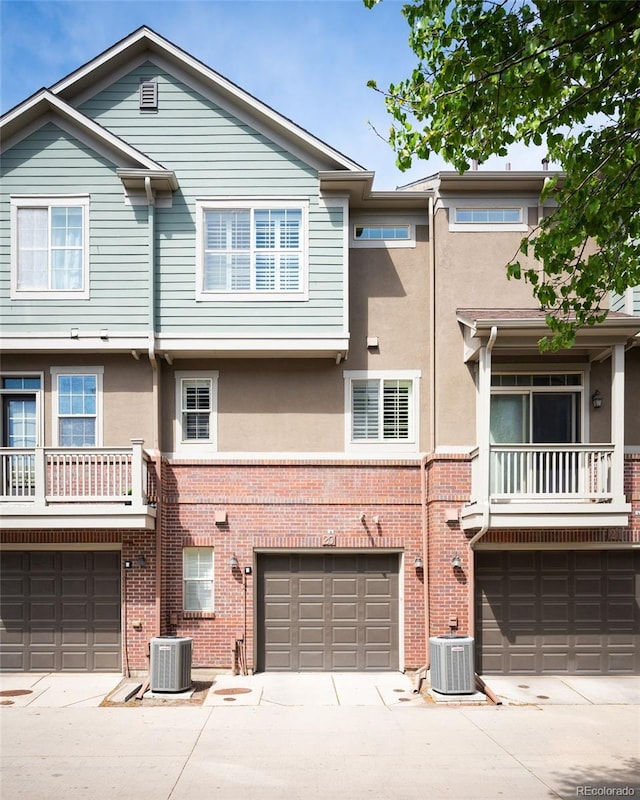 767 Roslyn St Unit 20, Denver, CO 80230 - view of front of house featuring an attached garage, central AC unit, stucco siding, and driveway