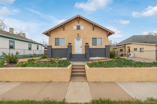 bungalow featuring fence and stucco siding
