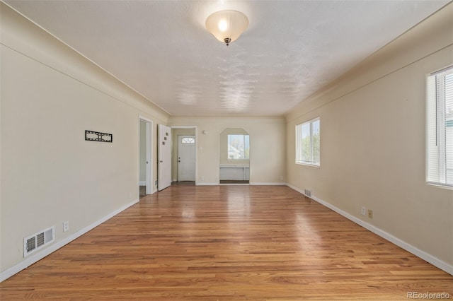 foyer entrance featuring visible vents, light wood-style floors, and baseboards
