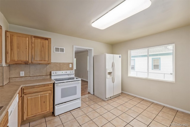 kitchen featuring light tile patterned flooring, white appliances, light countertops, backsplash, and visible vents