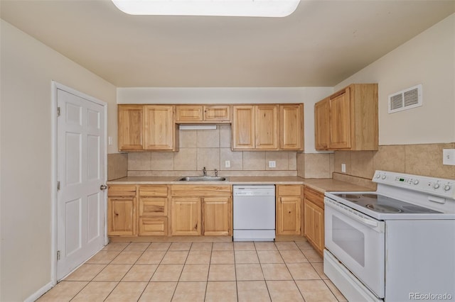 kitchen featuring visible vents, a sink, white appliances, and light countertops