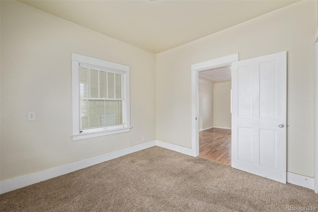 empty room featuring carpet floors and baseboards