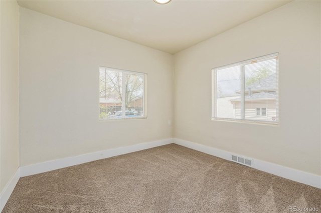 spare room with visible vents, baseboards, and carpet floors