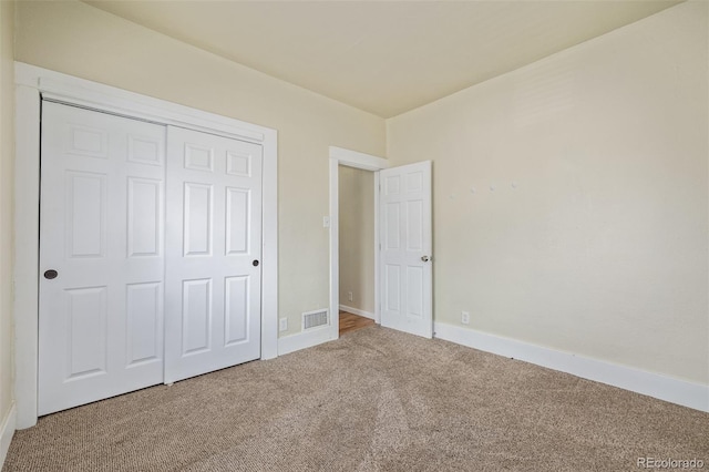unfurnished bedroom featuring a closet, baseboards, carpet flooring, and visible vents