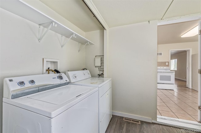 clothes washing area featuring baseboards, visible vents, laundry area, and washer and clothes dryer
