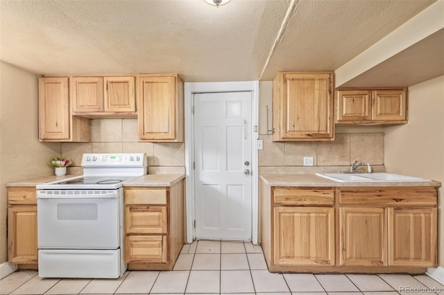 kitchen featuring white electric range, light countertops, light tile patterned floors, and light brown cabinetry