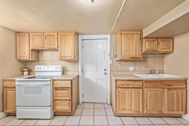 907 4th Ave And B, Unit A, Greeley, CO 80631 - kitchen featuring white electric range, light countertops, light tile patterned floors, and light brown cabinetry