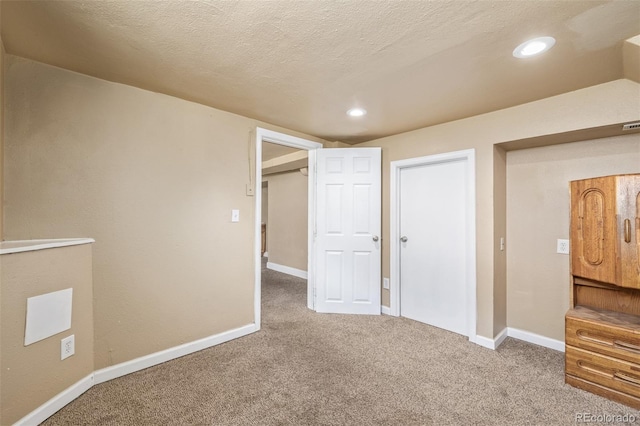 interior space with recessed lighting, baseboards, and a textured ceiling