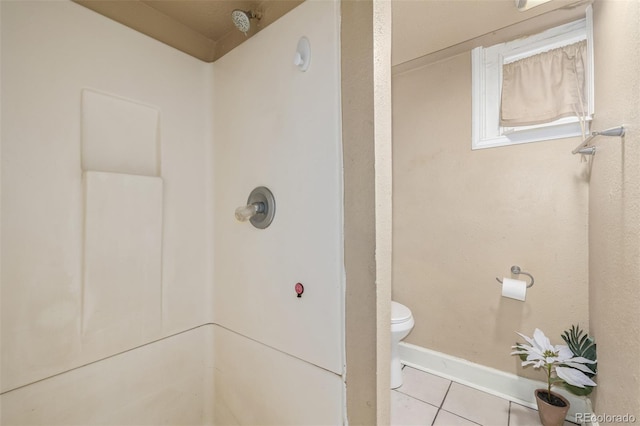 bathroom featuring toilet, tile patterned floors, walk in shower, and baseboards