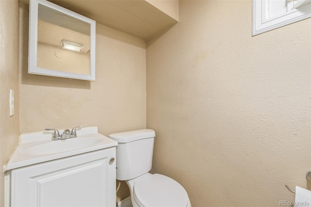 half bathroom with vanity and toilet