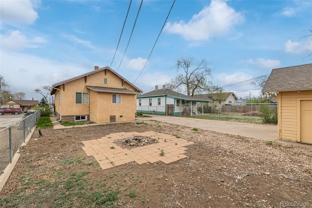 rear view of property with a patio area, a fire pit, and fence