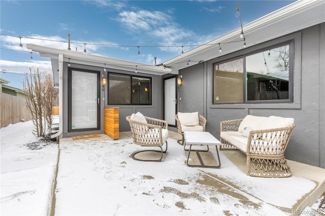 snow covered patio featuring fence