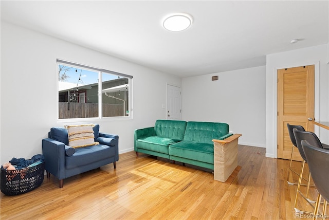 living area with baseboards and wood finished floors