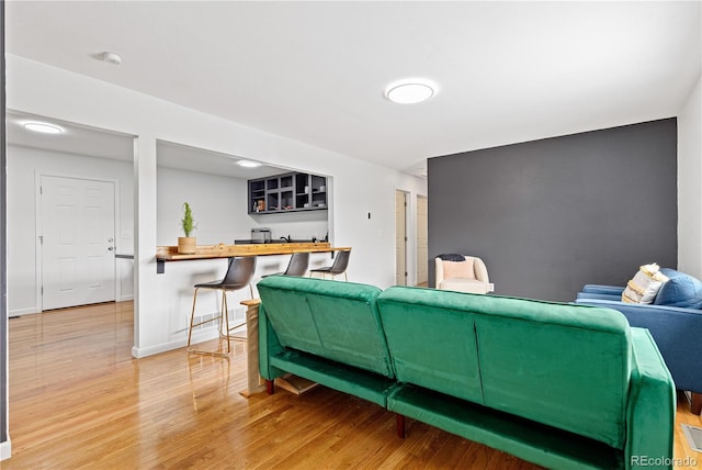 living area with baseboards and wood finished floors