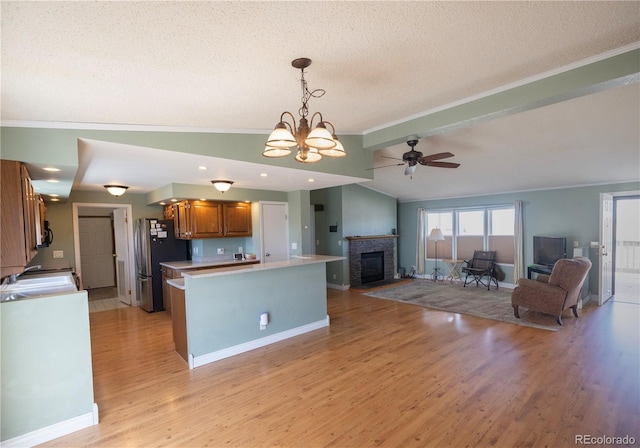 112 8th St, Hugo, CO 80821 - kitchen featuring freestanding refrigerator, crown molding, lofted ceiling, light wood-style floors, and brown cabinetry