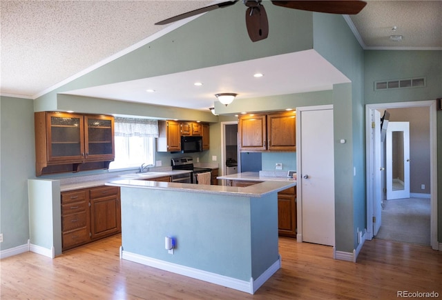 112 8th St, Hugo, CO 80821 - kitchen featuring electric stove, black microwave, brown cabinets, ornamental molding, and a sink