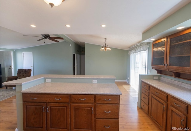 112 8th St, Hugo, CO 80821 - kitchen featuring vaulted ceiling, light wood-style flooring, light countertops, ceiling fan, and glass insert cabinets