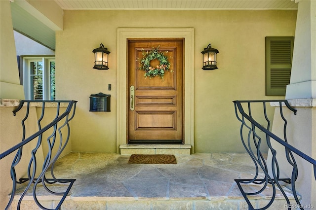 view of exterior entry featuring visible vents and stucco siding