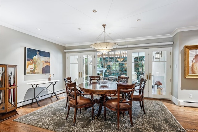 dining area featuring wood finished floors, a healthy amount of sunlight, ornamental molding, french doors, and baseboard heating