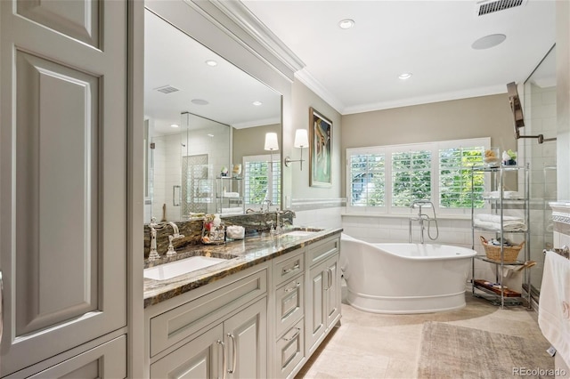 full bath featuring crown molding, a freestanding tub, a sink, and a shower stall