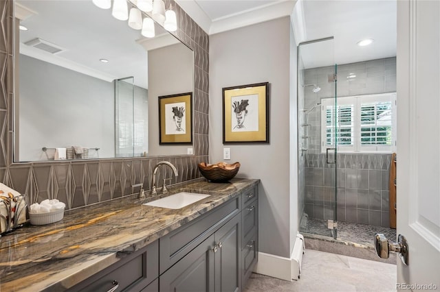 bathroom featuring crown molding, backsplash, a stall shower, vanity, and baseboards