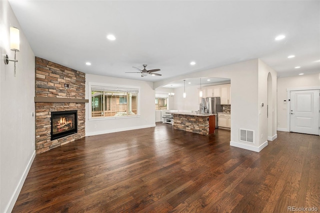 5372 W 68th Ave, Arvada, CO 80003 - unfurnished living room featuring arched walkways, a ceiling fan, visible vents, and dark wood finished floors