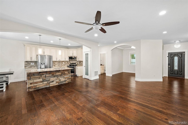5372 W 68th Ave, Arvada, CO 80003 - unfurnished living room featuring a sink, recessed lighting, arched walkways, a ceiling fan, and dark wood-style floors